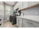 Efficient laundry room with modern washer and dryer, white cabinetry, and ample counter space at 18543 E Purple Sage Dr, Queen Creek, AZ 85142