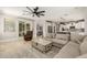 Open-concept living room featuring neutral decor, large windows, and seamless access to other living spaces at 18543 E Purple Sage Dr, Queen Creek, AZ 85142