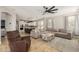 Spacious living room open to the kitchen featuring stylish furniture and a large ceiling fan at 18543 E Purple Sage Dr, Queen Creek, AZ 85142