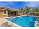 Sparkling pool featuring tanning ledge, stone decking, and covered patio with outdoor seating at 18543 E Purple Sage Dr, Queen Creek, AZ 85142