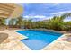 Inviting backyard pool with a waterfall feature, a basketball hoop, and a covered patio at 18543 E Purple Sage Dr, Queen Creek, AZ 85142