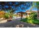 Lush backyard featuring a pool, gazebo, fire pit, and mature trees for ultimate privacy and relaxation at 18575 E Pine Barrens Ave, Queen Creek, AZ 85142