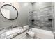 Updated bathroom featuring a granite vanity, modern fixtures, and a tiled shower-tub combo at 18575 E Pine Barrens Ave, Queen Creek, AZ 85142