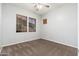 Bedroom with tan carpet flooring, two windows, and neutral walls at 18575 E Pine Barrens Ave, Queen Creek, AZ 85142