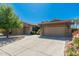 Home exterior with stone accents, tile roof, mature trees, and a spacious driveway at 18575 E Pine Barrens Ave, Queen Creek, AZ 85142