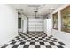 Garage with black and white checkered floor, storage cabinets, and garage door access at 18575 E Pine Barrens Ave, Queen Creek, AZ 85142