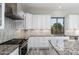 Bright kitchen featuring granite countertops, white cabinets with lighting, and stainless steel appliances at 18575 E Pine Barrens Ave, Queen Creek, AZ 85142