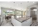 Bright kitchen with a large island, granite counters, white cabinets, and a view to the dining and living areas at 18575 E Pine Barrens Ave, Queen Creek, AZ 85142