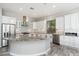 Elegant kitchen boasting white cabinets, granite countertops, stainless steel appliances, and stylish pendant lighting at 18575 E Pine Barrens Ave, Queen Creek, AZ 85142