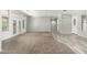 Open living room with carpet and wood-look floors, featuring French doors and neutral paint at 18575 E Pine Barrens Ave, Queen Creek, AZ 85142