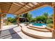 Relaxing backyard with pool, hot tub, gazebo, patio, and lush tropical landscaping for outdoor enjoyment at 18575 E Pine Barrens Ave, Queen Creek, AZ 85142