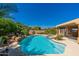 Inviting backyard pool with rock accents, spa, and lush landscaping creating a serene outdoor oasis at 18575 E Pine Barrens Ave, Queen Creek, AZ 85142
