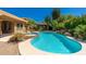 Stunning backyard pool and spa featuring lush landscaping, a rock waterfall, and a covered gazebo at 18575 E Pine Barrens Ave, Queen Creek, AZ 85142