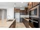 Well-equipped kitchen featuring dark wood cabinetry, granite countertops, and stainless steel appliances at 21296 N 270Th Ln, Buckeye, AZ 85396