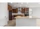 Bright kitchen featuring an island with granite countertop, dark cabinets, and modern stainless steel appliances at 21296 N 270Th Ln, Buckeye, AZ 85396