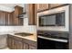 Modern kitchen featuring a stainless steel oven and cooktop, dark cabinets, and granite countertops at 21296 N 270Th Ln, Buckeye, AZ 85396