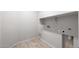 Functional laundry room with tile flooring, utility connections, and shelving for storage convenience at 21296 N 270Th Ln, Buckeye, AZ 85396