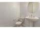 Modern half bathroom with a pedestal sink, oval mirror, and tile flooring at 21830 E Bonanza E Ct, Queen Creek, AZ 85142