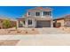 Two story home featuring a two car garage and a covered front porch, set against a clear blue sky at 21830 E Bonanza E Ct, Queen Creek, AZ 85142
