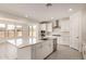 Bright, all-white kitchen featuring an island, stainless steel appliances, and tile flooring at 21830 E Bonanza E Ct, Queen Creek, AZ 85142