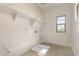 Well-lit laundry room with storage shelves and tile floors at 21830 E Bonanza E Ct, Queen Creek, AZ 85142