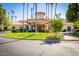 Elegant clubhouse entrance with a circular driveway, manicured landscaping, and palm tree lined drive at 2226 E Beachcomber Dr, Gilbert, AZ 85234