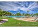 Beautiful community pool area with sandy beach, lounge chairs, and lush landscaping for relaxation and enjoyment at 2226 E Beachcomber Dr, Gilbert, AZ 85234