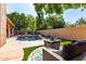 Backyard pool area with artificial turf, fire pit, and lounge seating at 2226 E Beachcomber Dr, Gilbert, AZ 85234