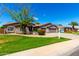 Inviting single-story home with a well-manicured lawn and mature trees on a sunny day at 2698 E Carla Vista Dr, Gilbert, AZ 85295