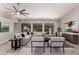 Bright living room featuring a large sectional sofa, ceiling fan, and contemporary decor at 2698 E Carla Vista Dr, Gilbert, AZ 85295