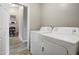 Convenient laundry room with washer and dryer, leading to a hallway and additional storage at 2727 S Sawyer Cir, Mesa, AZ 85209
