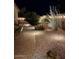 Backyard featuring desert landscaping, accent lighting, and a cozy patio area at 289 W Ironhorse Ln, San Tan Valley, AZ 85143
