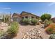 View of a home's charming, desert-style front yard with cacti, succulents, and stone accents at 289 W Ironhorse Ln, San Tan Valley, AZ 85143