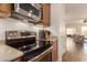 Stainless steel stove and microwave in a kitchen leading to the living room at 289 W Ironhorse Ln, San Tan Valley, AZ 85143