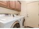 Functional laundry room equipped with a washer, dryer, and overhead storage cabinets at 289 W Ironhorse Ln, San Tan Valley, AZ 85143