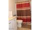 Cozy bathroom featuring a vanity with white cabinetry and a red striped shower curtain at 303 S Recker Rd # 218, Mesa, AZ 85206