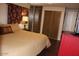 Bedroom featuring a comfortable bed, closet and stylish red dresser at 303 S Recker Rd # 218, Mesa, AZ 85206