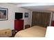 Bedroom featuring a comfortable bed, closet, red dresser and two pieces of artwork at 303 S Recker Rd # 218, Mesa, AZ 85206
