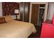 Relaxing bedroom featuring a cozy bed, a red dresser, and practical closet organizers for tidy storage at 303 S Recker Rd # 218, Mesa, AZ 85206