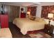 Bedroom featuring a comfortable bed, closet, a red dresser and wood flooring at 303 S Recker Rd # 218, Mesa, AZ 85206