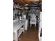 View of a room with a sink, shelving, stove, freezer and stacks of chairs at 303 S Recker Rd # 218, Mesa, AZ 85206