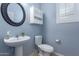 Stylish powder room features a round mirror, floating sink, and cabinet for storage at 3129 E Franklin Ave, Gilbert, AZ 85295