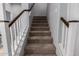 Carpeted staircase with white and brown railings, leading to the next level of the home at 3129 E Franklin Ave, Gilbert, AZ 85295