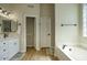 Bright bathroom featuring double vanity, soaking tub, and a glass block window for natural light at 3564 N Tuscany --, Mesa, AZ 85207