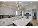 Well-lit kitchen with stainless steel appliances, white cabinets, island and eat-in counter seating at 3564 N Tuscany --, Mesa, AZ 85207