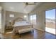 Spacious bedroom with a ceiling fan, laminate floors, balcony access, and lots of natural light at 3564 N Tuscany --, Mesa, AZ 85207