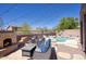 Charming patio with comfortable outdoor seating, fireplace, string lights, and a view of the pool at 3564 N Tuscany --, Mesa, AZ 85207