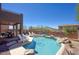 Beautiful pool with rock features and cool, clear water is surrounded by chairs and desert landscaping at 3564 N Tuscany --, Mesa, AZ 85207