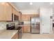 Well-lit kitchen with stainless steel appliances and light wood cabinetry at 3871 S Marion Way, Chandler, AZ 85286
