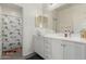 Bathroom featuring a single vanity with white cabinets and a tub/shower combo at 399 N 157Th Ln, Goodyear, AZ 85338